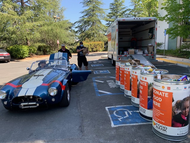 El coche Cobra está aparcado junto a los barriles de recogida de alimentos.