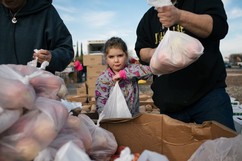 A child picks up food during our disaster response at the 2019 Camp fire.