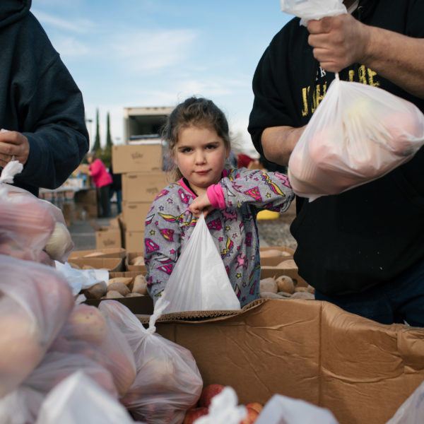 Un niño recoge comida durante nuestra respuesta al desastre en el incendio Camp de 2019.