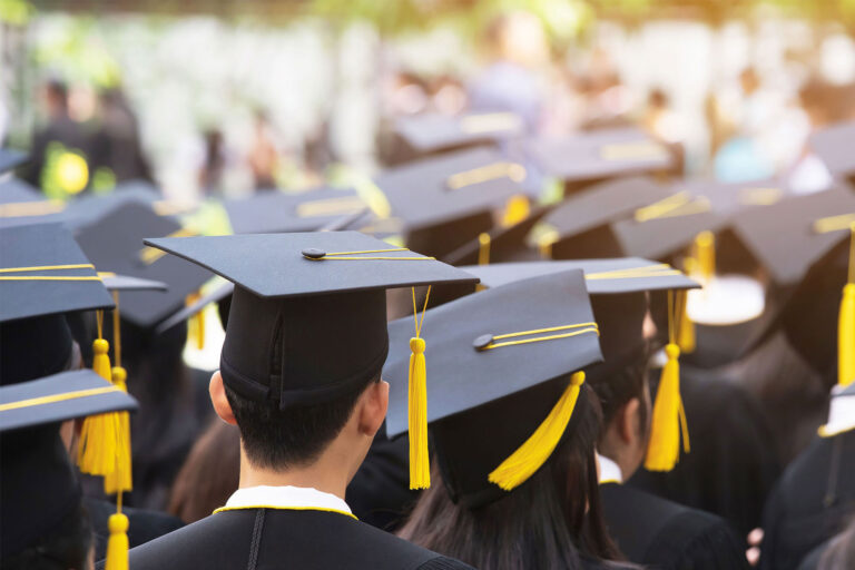 A group of college graduates photographed from behind.