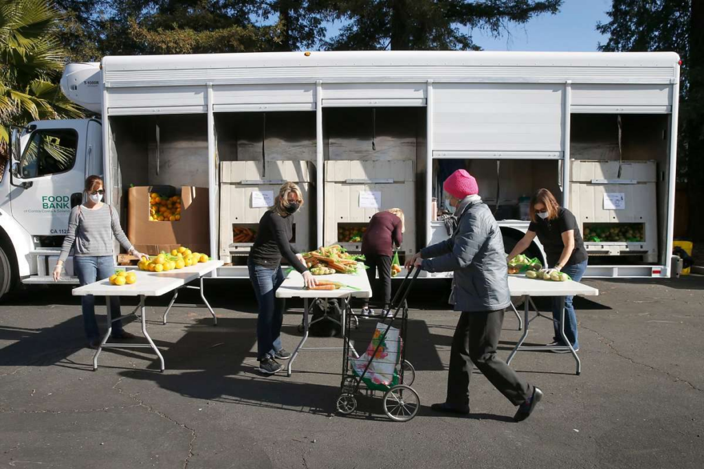 A person in a pink hat visits a Community Produce Program distribution.