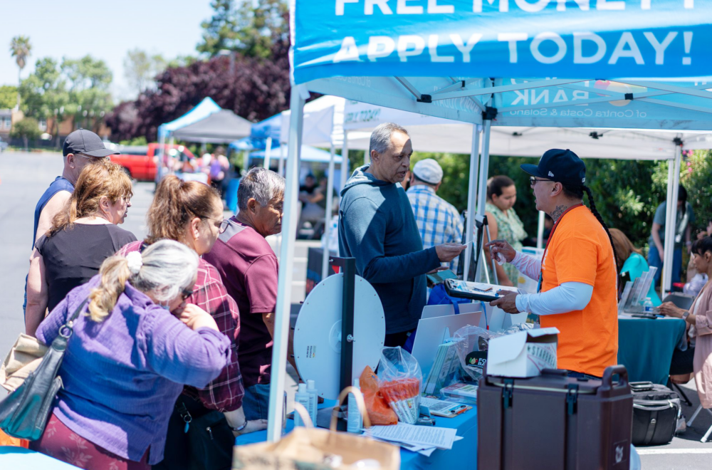 People in line at a CalFresh outreach booth.