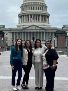 Four women post in front of the Capitol Building in Washington, D.C.