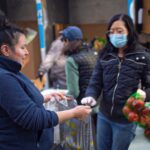 Cliente recibe productos frescos en la distribución del Banco de Alimentos.