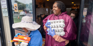 Two volunteers hand out food at a Food Bank partner agency.