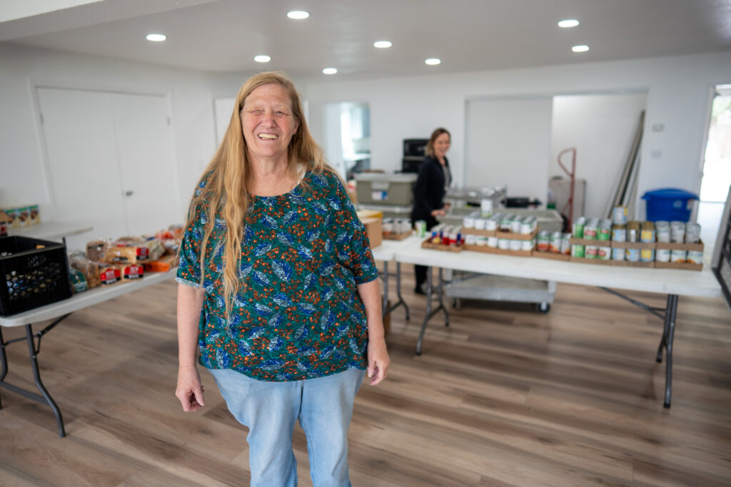 A woman stands in a food pantry.
