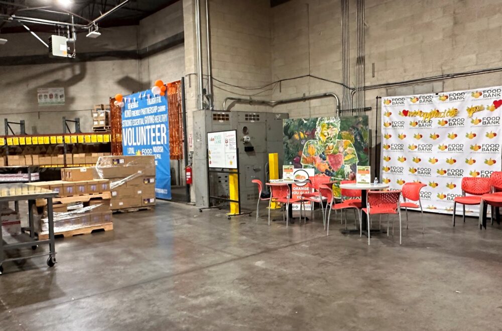 A cinderblock warehouse. Some tables and chairs are set up against one wall.