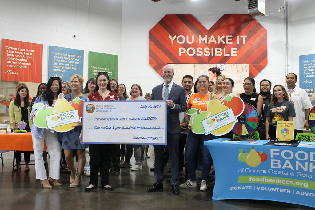 Staff and Sen. Steve Glazer hold a large novelty check.