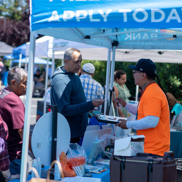 A CalFesh team member talks to the public at a resource fair.