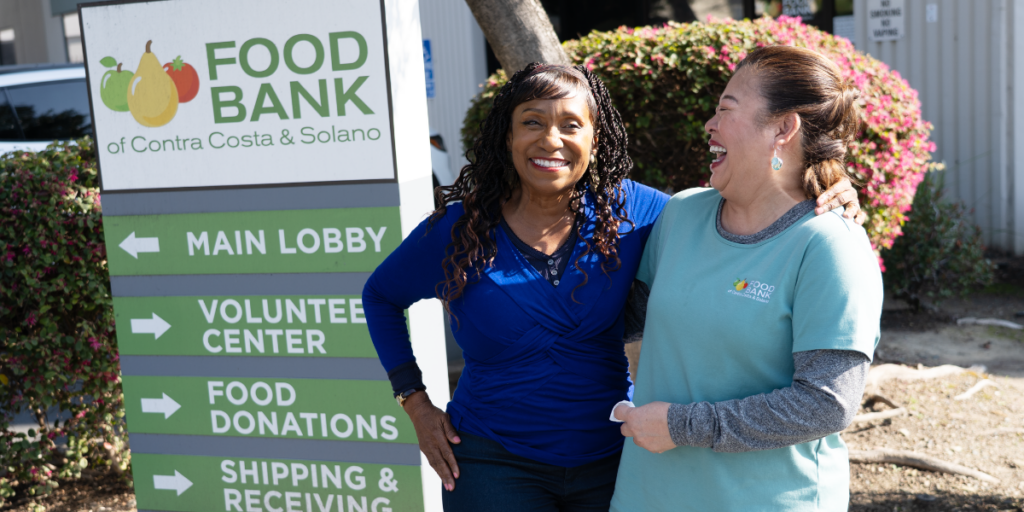 Annette and Bee stand outside the Food Bank.