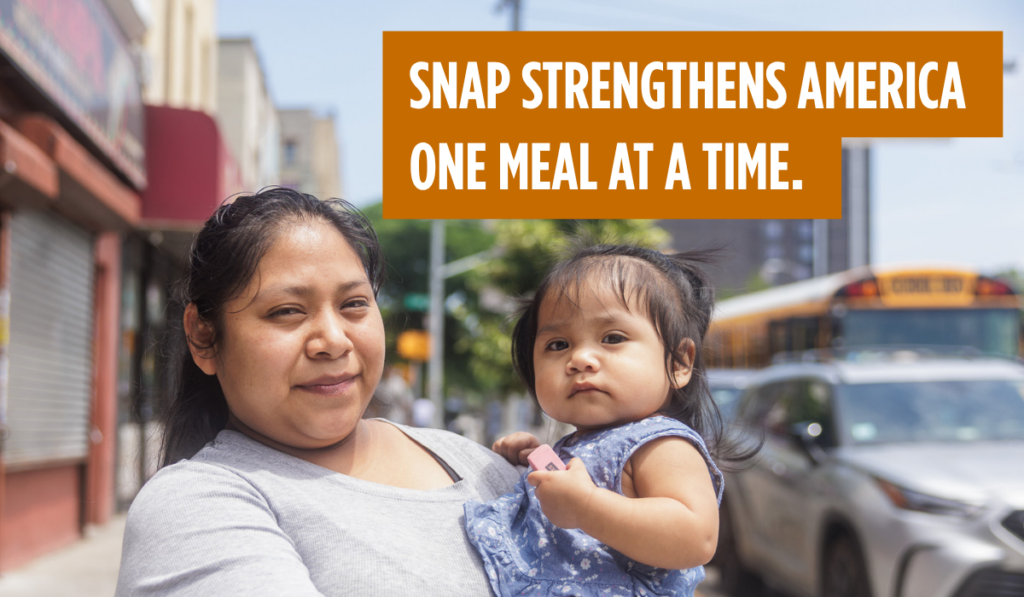 Una madre sostiene a su hijo pequeño y mira directamente a la cámara. SNAP fortalece a Estados Unidos, una comida a la vez.